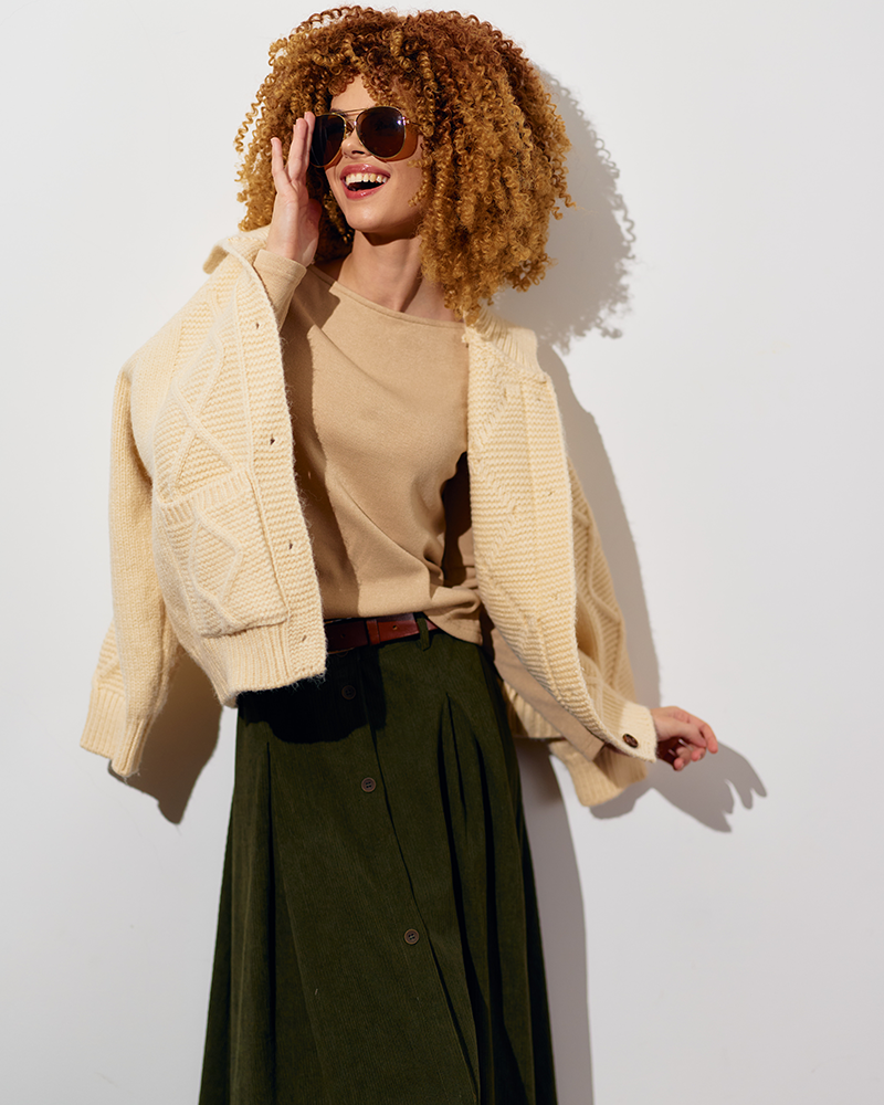 Chica con falda verde y chaqueta de lana.